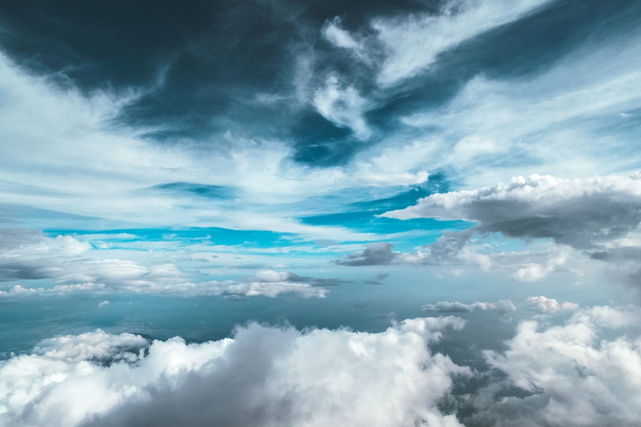 Majestic clouds and vibrant blue sky create a stunning cloudscape above the horizon.